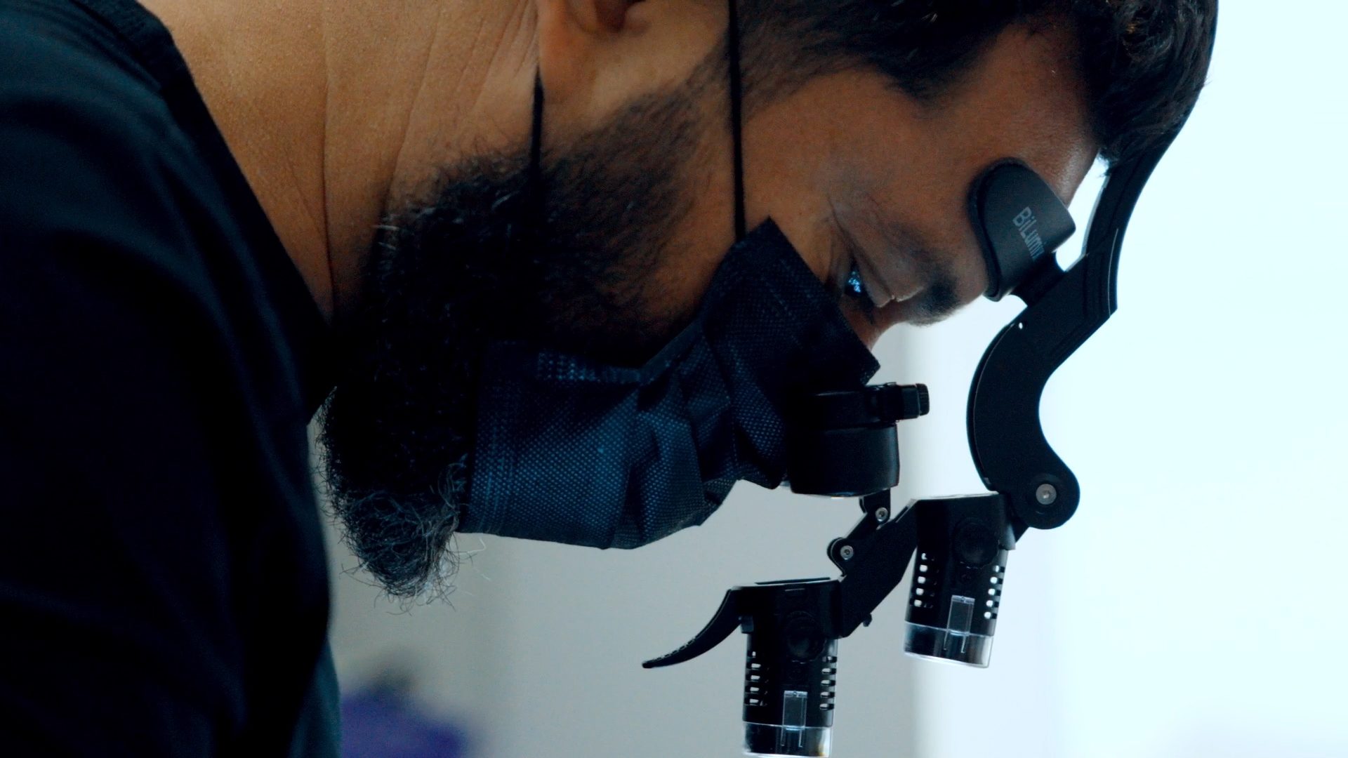 Dr. Alejandro Mora performing a precise biological veneer procedure with surgical loupes